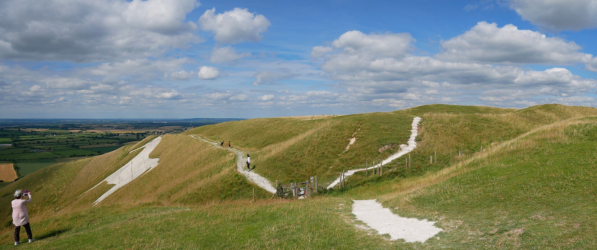 The ramparts of Bratton Camp, with part of the Westbury White Horse on the slope to the left and the plain below